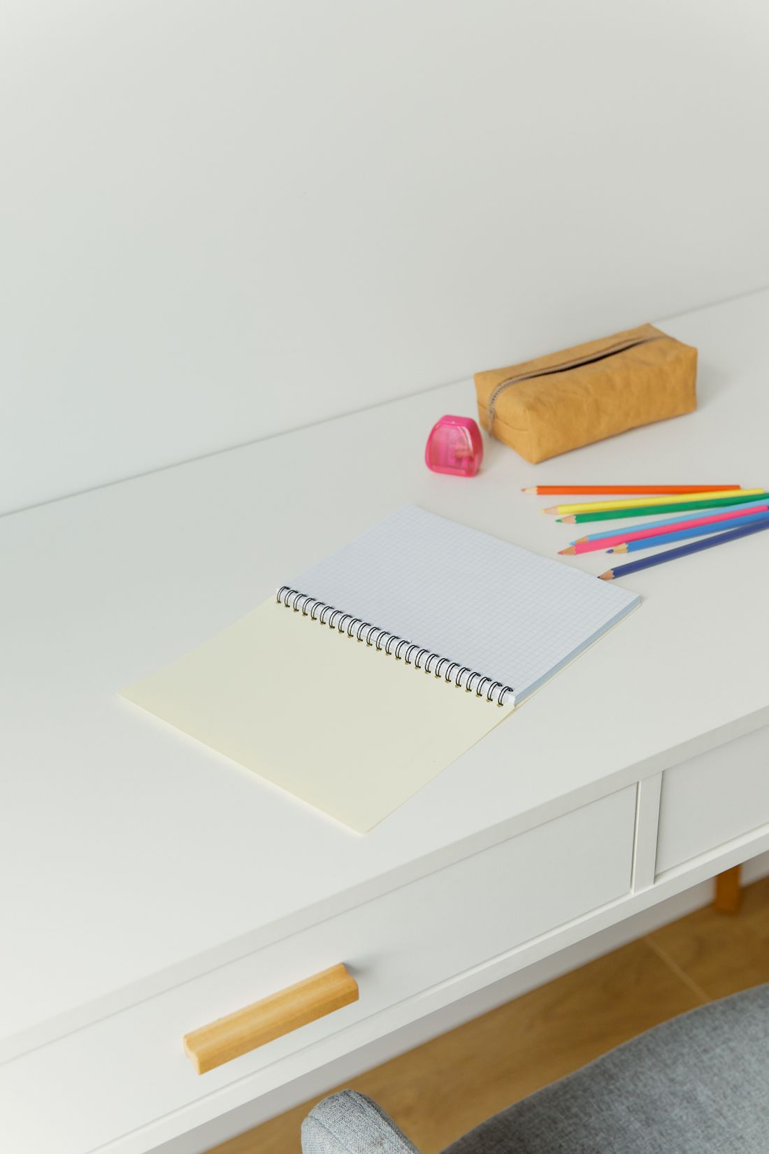 A notebook with colored pencils and stationery.