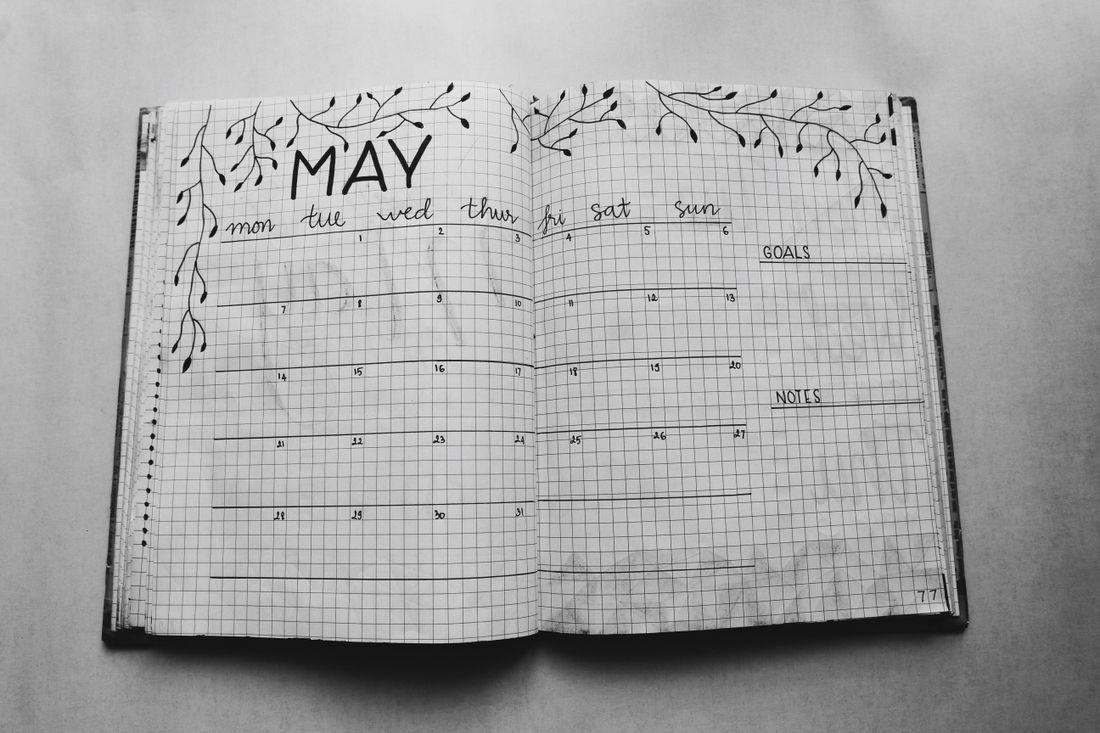 A handwritten monthly planner in an open notebook.